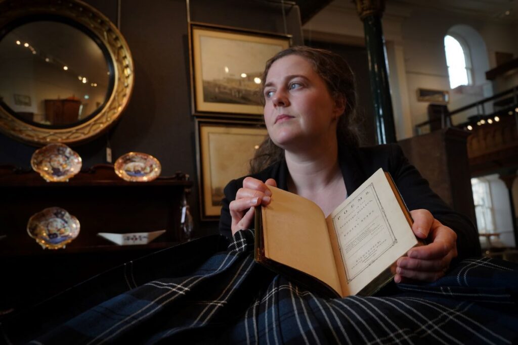 Cathy Marsden, Head of Rare Books at Lyon & Turnbull, with the rare first edition of Robert Burns' Poems. Credit: Stewart Attwood