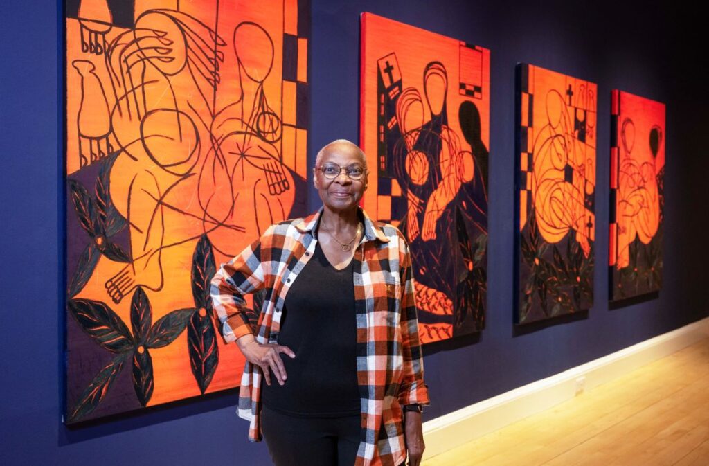 The artist, Everlyn Nicodemus, with works from her new series, Lazarus Jacaranda (2022–24), created for the exhibition. Credit: Neil Hanna