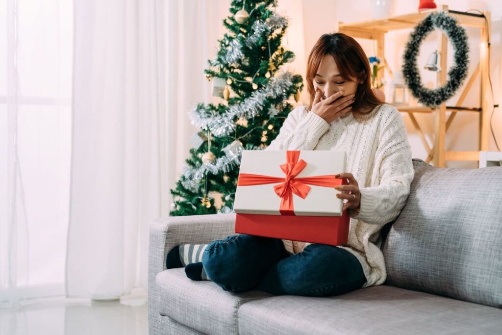 Receiving a gift on Christmas morning in a festive home living room interior.
By PR Image Factory / Adobe Stock