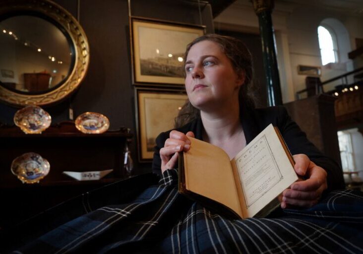 Cathy Marsden, Head of Rare Books at Lyon & Turnbull, with the rare first edition of Robert Burns' Poems. Credit: Stewart Attwood