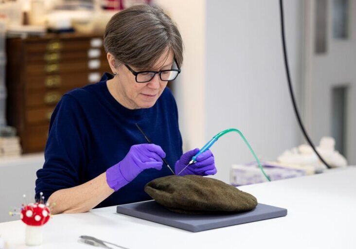 Conservator Lynn McClean prepares the Arnish Moor Man's knitted bonnet. Credit: Duncan McClean 