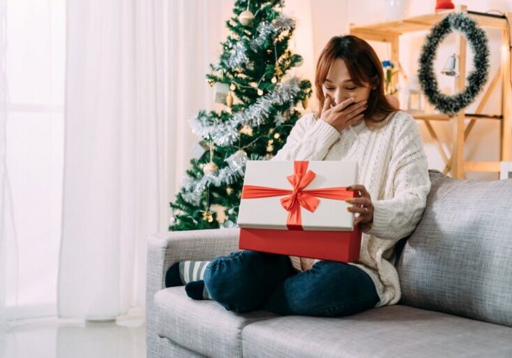 Receiving a gift on Christmas morning in a festive home living room interior.
By PR Image Factory / Adobe Stock