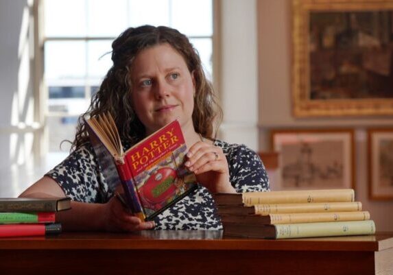 Specialist Cathy Marsden with a First Edition Harry Potter. Credit: Stewart Attwood